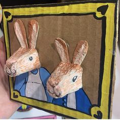 someone is holding up a paper cut out of two rabbits