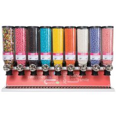 a row of candy machines sitting on top of a metal shelf next to each other