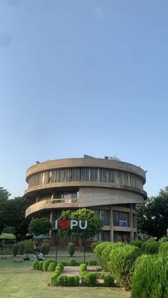 a circular building with trees and bushes around it