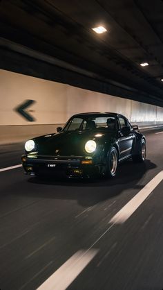 a black car driving through a tunnel at night