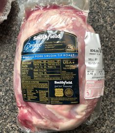 an uncooked ham is wrapped in plastic on the counter next to it's packaged package