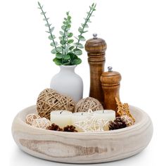 a wooden bowl filled with candles and other items