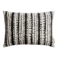 a black and white striped pillow with fringes on the front, in an embroidered pattern