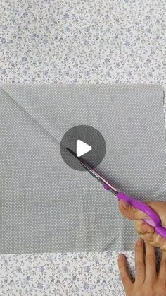 someone is using a purple toothbrush to cut the fabric off of a piece of cloth