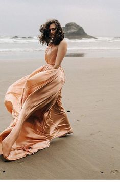 a woman in an orange dress on the beach