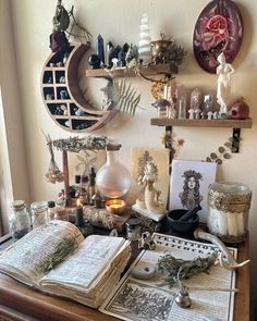 a desk with many items on top of it and some candles in the corner next to them