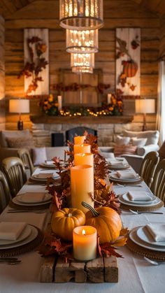 a long table with candles and pumpkins on it