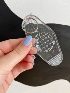 a hand holding a cell phone case with glitter on it