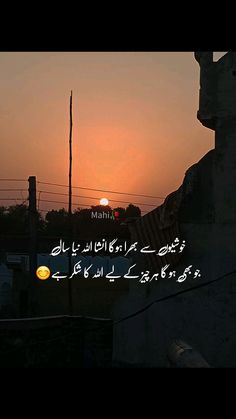 the sun is setting over some buildings with arabic writing in front of it and an orange light