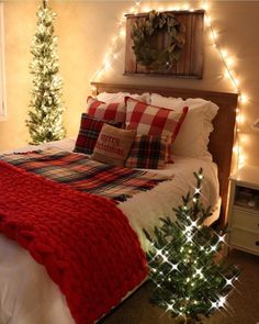 a bedroom decorated for christmas with lights on the headboard and bed in front of it