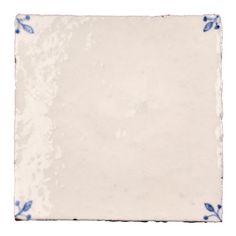 a white and blue tile with flowers on it's edges, against a white background