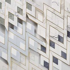 an abstract marble wall with gold and silver geometric shapes on it's sides, including rectangles