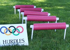 pink chairs are lined up next to a sign for the olympics