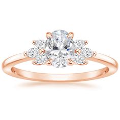 a yellow gold engagement ring with three stones on the band and an oval center stone