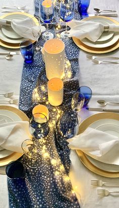 the table is set with blue and white plates, silverware, and candlesticks