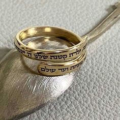 This personalized custom-engraved gold-filled ring is a delicate treasure designed to commemorate special moments and serve as an ideal Bat Mitzvah gift.  Crafted with meticulous attention to detail, this slim and elegant gold-filled ring becomes a canvas for your expression with the option to engrave up to 100 characters. The Hebrew engraving reads:  'Noam, Our little girl, The Lord will guard you, going and coming, Now and Forever.' This verse is a part of 'Shir Lama'alot' - The Song of Ascent Dainty Gold-plated Sterling Silver Engraved Ring, Dainty Engraved Sterling Silver Ring In Gold, Dainty Engraved Gold Stackable Rings, Dainty Gold Engraved Stackable Rings, Brass Engraved Ring For Promise, Gold Engraved Promise Ring In Recycled Gold, Gold Sterling Silver Stackable Engraved Ring, Yellow Gold Brass Stackable Rings For Wedding, Spiritual 14k Gold Engraved Wedding Ring