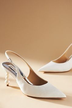 two white shoes with pearls on the heel