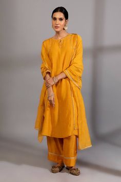 Mustard yellow chanderi mul kurta with keyhole round neck and metallic zardozi placement embroidery. Paired with straight pant and embroidered dupatta.
Components: 3
Pattern: Hand Embroidered 
Type Of Work: Zardozi Work
Neckline: Keyhole Round Neck
Sleeve Type: Three Quarter Sleeves
Fabric: Chanderi Mul, Cotton Silk
Color: Yellow
Other Details: 
Side slits on kurta
Scalloped lace dupatta hem
Embroidered pant border
Length:
Kurta: 45 inches
Pant: 37 inches
Dupatta: 95 x 40 inches
Note: The inner Mustard Anarkali Kurta For Diwali, Festive Yellow Pant Set With Resham Embroidery, Mustard Straight Kurta Set For Eid, Mustard Straight Kurta For Diwali, Festive Mustard Straight Kurta, Festive Mustard Straight Kurta Set, Yellow Festive Pant Set, Yellow Chanderi Straight Kurta Palazzo Set, Festive Yellow Pant Set For Eid