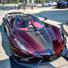 a red and black sports car parked on the street