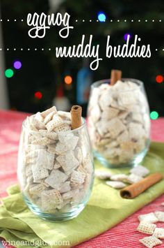 two glass bowls filled with muddy buddies on top of a table next to cinnamon sticks