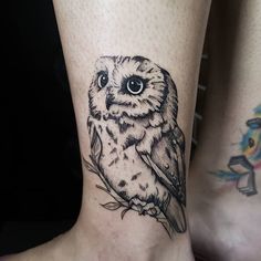 an owl tattoo on the leg of a woman