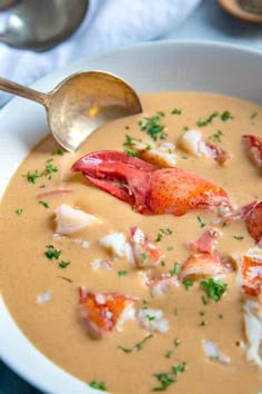 a bowl of lobster chowee with a spoon in it