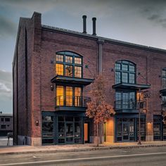 an old brick building with many windows and balconies on the top floor is lit up at night