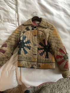 an old quilted jacket is laying on a bed