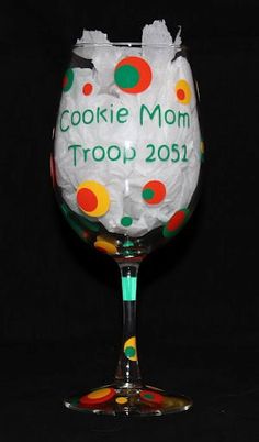 a decorated wine glass with the words cookie mom troop on it