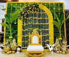 a white chair sitting in front of a yellow and white backdrop with flowers on it