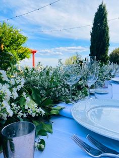 the table is set with white flowers and silverware