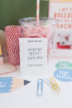 a cup with candy sticks and paper clips in it sitting on top of a table