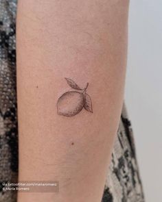 a small lemon tattoo on the arm