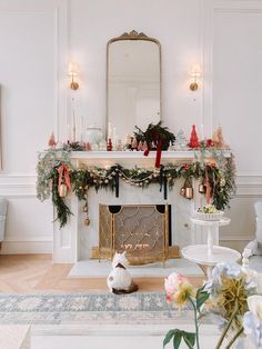 a living room with a fire place decorated for christmas