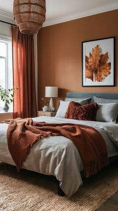 a bedroom with an orange and brown color scheme on the walls, bedding, and rugs