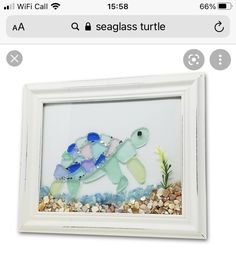 a sea glass turtle in a white frame