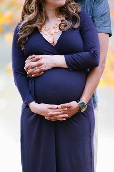 a pregnant woman is holding her husband's belly