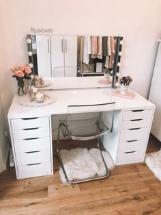 a white vanity with drawers, mirror and stool