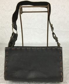 "Here we have a vintage brown leather footed Purse with a wide strap, metal studs and large buckle. This has a great retro look. This is in very nice condition considering its age. I noticed some light scratches but no ther problems. It measures: Height - 6\" Width - 9 3/4\" Depth - 4 1/4\" Strap Drop - 11 1/4\" I try my best to give accurate descriptions, although I am no expert, plus I'm human and sometimes I might miss a flaw. I always provide high resolution photos and consider them to be pa Brown Leather Shoulder Bag With Buckle Closure, Brown Rectangular Satchel With Buckle Closure, Leather Satchel Shoulder Bag With Rivets, Rectangular Leather Bag With Rivets, Vintage Leather Bags With Metal Hardware, Vintage Brown Faux Leather Shoulder Bag, Retro Leather Shoulder Bag With Metal Hardware, Brown Leather Bags With Rivets, Steampunk Leather Bag With Belt Loops