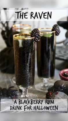 two glasses filled with blackberry rum drink on top of a table next to halloween decorations