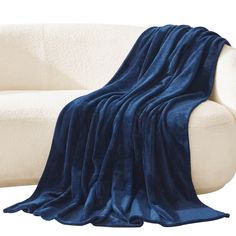 a white couch with a blue blanket on it