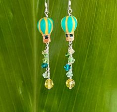 Fully glazed and decorated Peruvian ceramic aqua and yellow Hot Air Balloon beads trail vibrant authentic Swarovski Crystals on Sterling chain. Hang 2 inches below Sterling hooks. Free Shipping, Gift box included. Whimsical Yellow Jewelry With Ear Wire, Whimsical Green Nickel-free Jewelry, Fun Jewelry With Dangling Beads For Gift, Fun Dangling Beads Jewelry As Gift, Fun Dangling Beads Jewelry For Gifts, Handmade Green Jewelry With A Fun Style, Handmade Fun Green Jewelry, Handmade Green Fun Jewelry, Fun Yellow Nickel-free Jewelry