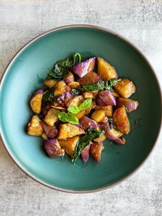 a blue plate topped with potatoes and spinach