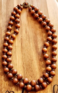 2 strand vintage necklace with wood beads and an ornate clasp. Elegant Multi-strand Wooden Beads, Vintage Brown Wooden Bead Necklaces, Elegant Multi-strand Necklaces With Wooden Beads, Elegant Multi-strand Necklace With Wooden Beads, Vintage Brown Beaded Necklace With Wooden Beads, Brown Wooden Beaded Jewelry, Beaded Natural Wood Jewelry, Traditional Multi-strand Wooden Bead Necklaces, Handmade Brown Double Strand Necklaces