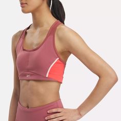 This Reebok sports bra offers medium support for spin class or personal training sessions. It has a pullover design, with removable pads for shaping and coverage. Angled side seams give you stability and support. When it's time to up the intensity, Speedwick tech helps wick sweat away from your skin. Color Block Sports Bra Athleisure, Athleisure Color Block Sports Bra, Pink Nylon Sports Bra For Light Exercise, Functional Pink Sports Bra With Built-in Padding, Color Block Athleisure Sports Bra For Training, Athleisure Color Block Sports Bra For Training, Sporty Color Block Sports Bra For Training, Functional Pink Sports Bra With Athletic Fit, Pink Sporty Activewear With Medium Bust Support