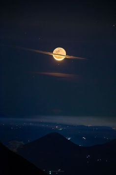 the moon is shining brightly in the night sky over mountains and valleys with lights on them