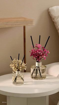 two vases with flowers are sitting on a table