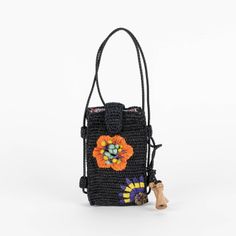 a small black bag with an orange flower on the front and a brown wooden handle