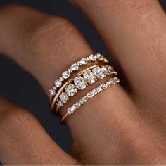 a woman's hand with three different rings on her finger and the ring has diamonds in it