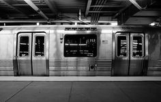 an empty subway car parked in a station with its doors open to let passengers on